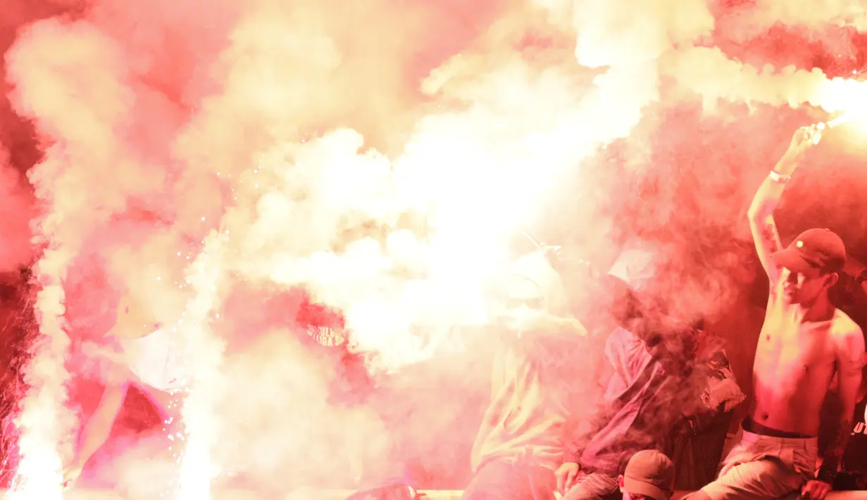 Suporter PSS Sleman menyalakan flare saat melawan Semen Padang pada laga Liga 2 di Stadion Pakansari, Jawa Barat, Selasa (4/12). PSS menang 2-0 atas Semen Padang. (Bola.com/M. Iqbal Ichsan)