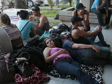 Sejumlah imigran Kuba beristirahat di luar gedung bea cukai di perbatasan antara Nikaragua dan Kosta Rika, Minggu (15/11). Nikaragua menutup perbatasannya dengan Kosta Rika hingga ribuan orang yang menuju Amerika terlantar. (REUTERS/Oswaldo Rivas)