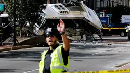 Petugas berjaga di garis polisi di lokasi kejadian tabrakan dua bus di Newark, New Jersey (19/08) waktu setempat. Seorang pengemudi bus New Jersey Transit tewas dan 19 orang dirawat di rumah sakit. (REUTERS/Eduardo Munoz)