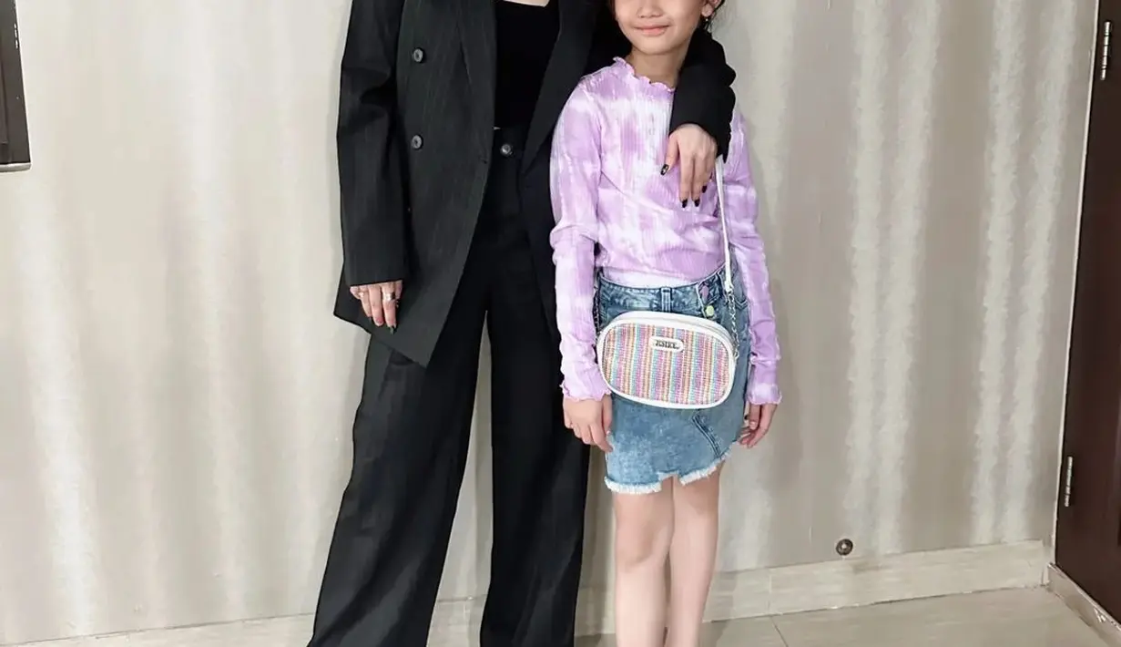 Di sini Ayu Ting Ting berpose bersama sang putri Bilqis. Ayu Ting Ting mengenakan setelan kerja serba hitam; tank top, blazer dan celana panjang. [Foto: Instagram/ayutingting92]