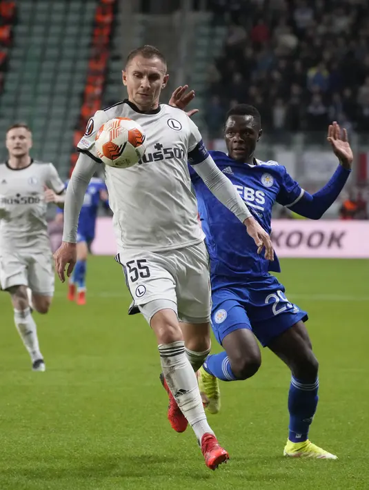 Bek Artur Legia Warszawa Jedrzejczyk berebut bola dengan penyerang Leicester City, Patson Daka pada matchday kedua Grup C Liga Europa 2021/2022 di Polish Army stadium, Kamis (31/9/2021). Leicester City kalah 0-1 di markas Legia Warszawa. (AP Photo/Czarek Sokolowski)