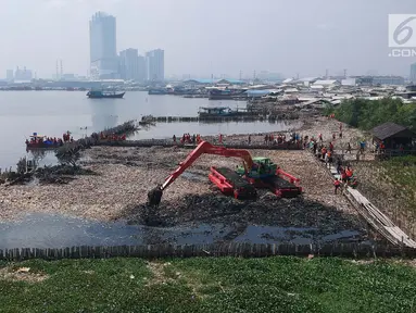 Petugas dengan menggunakan eskavator melakukan pengerukan sampah di kawasan Hutan Mangrove Ecomarine Muara Angke, Jakarta Utara, Minggu (18/3). Sampah itu terkumpul akibat gulungan ombak yang membawa sampah ke bibir pantai. (Liputan6.com/Arya Manggala)