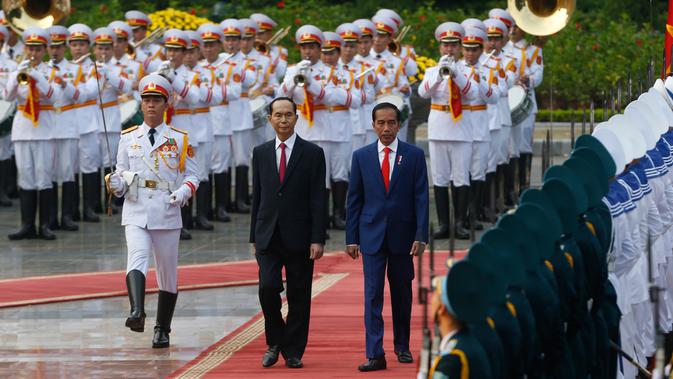 Presiden Joko Widodo dan Presiden Vietnam Tran Dai Quang berjalan saat upacara penyambutan di Istana Presiden, Hanoi, Vietnam (11/9). Usai lawatannya ke Korsel, Jokowi dan Ibu Negara Iriana beserta rombongan melanjutkan ke Vietnam. (Kham/AP Photo)