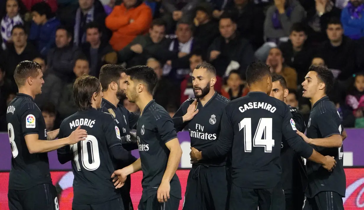 Striker Real Madrid, Karim Benzema berselebrasi usai mencetak gol ke gawang Real Valladolid selama pertandingan lanjutan La Liga Spanyol di stadion Jose Zorrilla,Valladolid (10/3). Benzema mencetak dua gol dipertanding tersebut.  (AFP Photo/Cesar Manso)