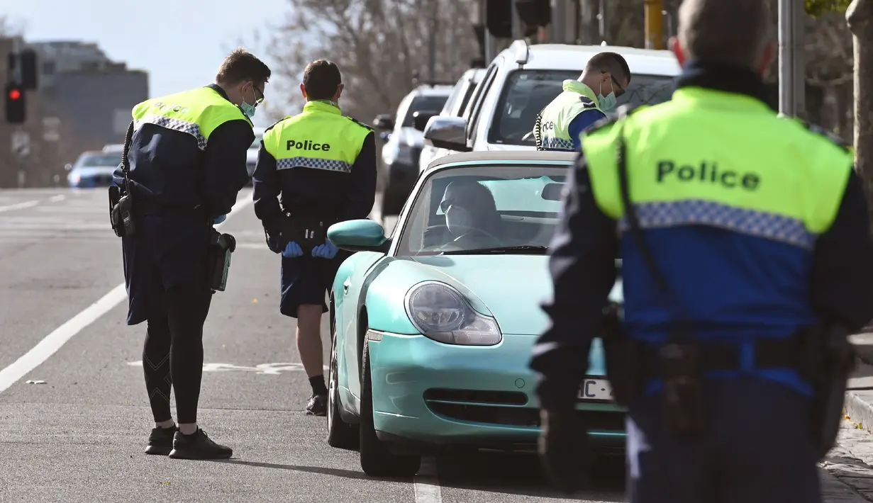 Petugas polisi menghentikan mobil untuk pemeriksaan izin selama tahap empat penguncian kota yang ketat karena wabah COVID-19 di Melbourne (11/8/2020). Negara bagian Victoria melaporkan 19 kematian akibat virus corona pada 11 Agustus. (AFP/William West)