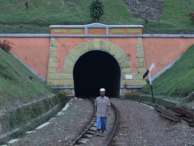 Warga melintas di rel sekitar terowongan Sasaksaat, Bandung Barat, Jawa Barat, Selasa (5/7). Terowongan yang memiliki panjang sekitar 949 meter tersebut menjadi terowongan kereta terpanjang di Indonesia yang masih aktif. (Liputan6.com/Immanuel Antonius)