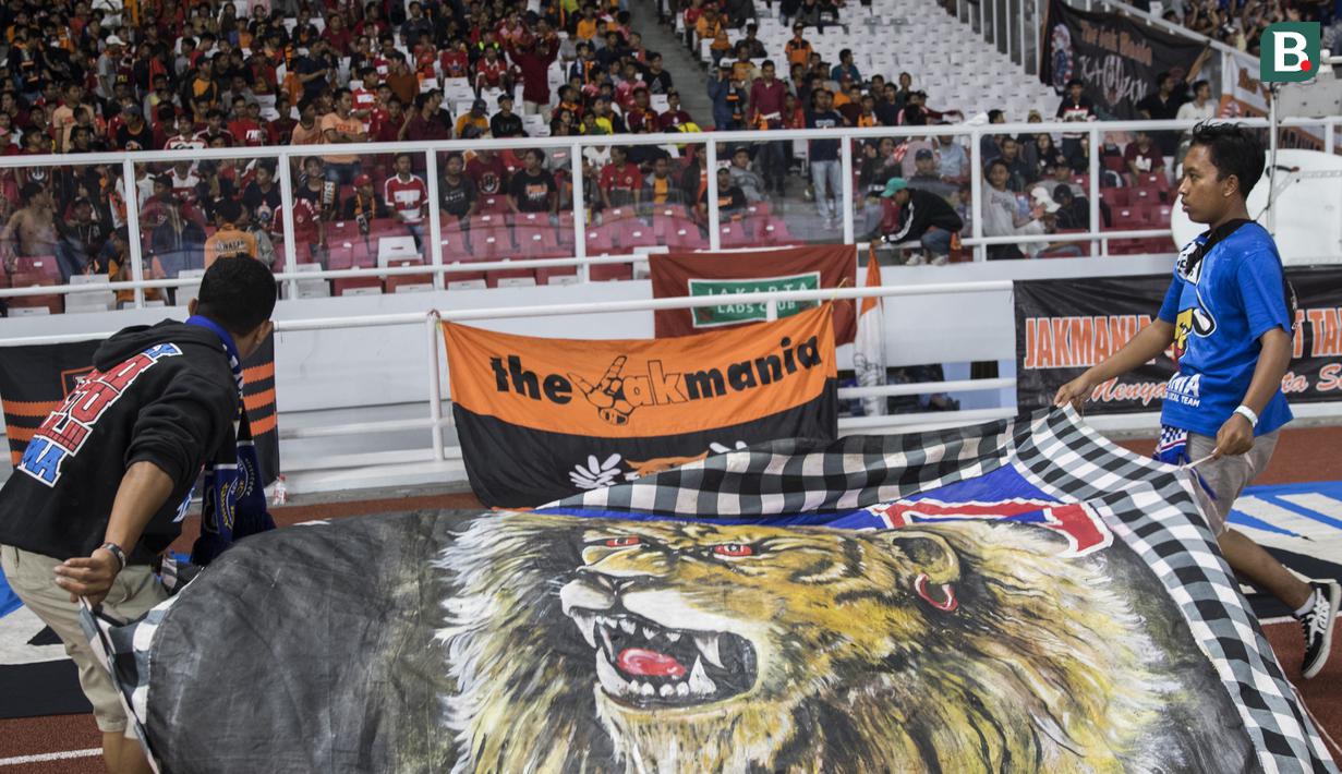 Suporter Arema FC, Aremania, memasang spanduk saat menonton laga Liga 1 melawan Persija Jakarta di SUGBK, Jakarta, Sabtu (31/3/2018). Persija menangn 3-1 atas Arema FC. (Bola.com/Vitalis Yogi Trisna)