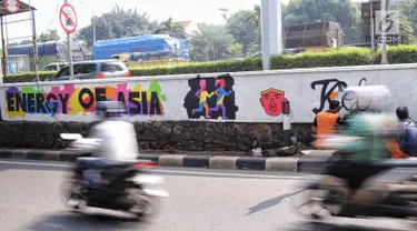 Petugas PSSU menyelesaikan mural bertema Asian Games di kawasan Tanjung Barat, Jakarta, Kamis (31/5). Mural itu dibuat untuk sosialisasi sekaligus bentuk dukungan terhadap perhelatan Asian Games pada Agustus 2018 mendatang. (Liputan6.com/Faizal Fanani)