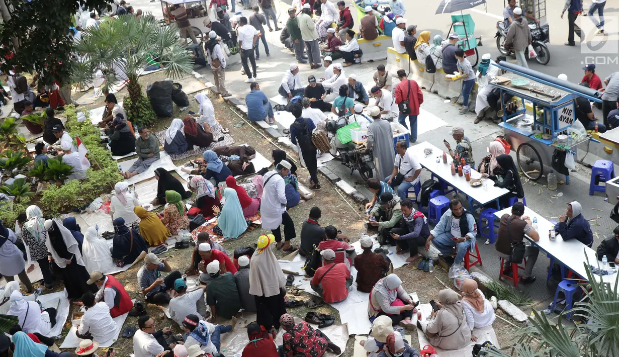Massa aksi duduk-duduk beristirahat di taman pembatas Jalan Medan Merdeka Barat, Jakarta, Kamis (27/6/2019). Massa aksi berkumpul terkait pelaksanaan sidang putusan perselisihan hasil Pilpres 2019 di Gedung Mahkamah Konstitusi. (Liputan6.com/Helmi Fithriansyah)