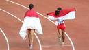 Selebrasi putri Indonesia, Rini Budiarti (kiri) yang meraih medali perak dan Triyaningsih meraih emas nomor lari 5.000m SEA Games 2015. (Bola.com/Arief Bagus)