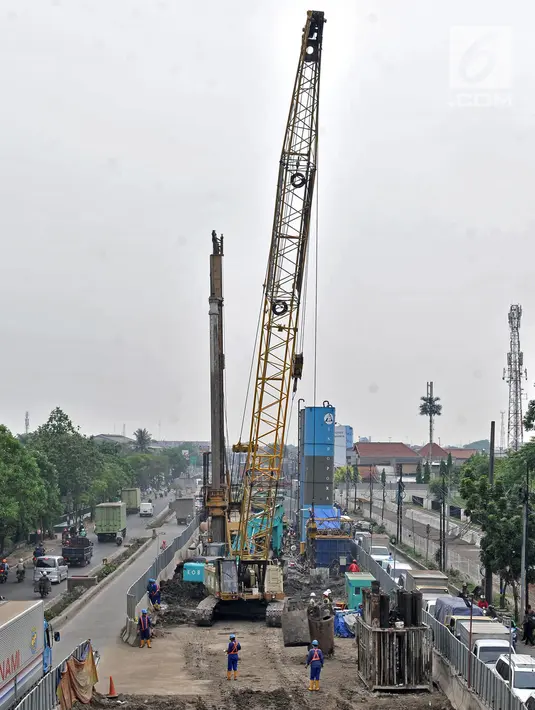 Pekerja menggunakan alat berat saat pembangunan proyek enam ruas tol dalam kota seksi 1A di kawasan Cakung, Jakarta, Senin (5/11). Proyek enam ruas tol dalam kota memiliki panjang mencapai 69,77 Km. (Liputan6.com/Iqbal Nugroho)