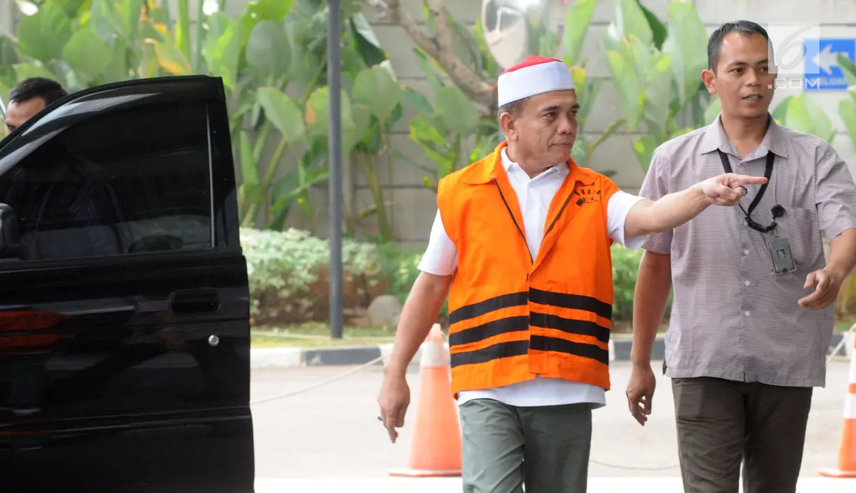 Gubernur Aceh Irwandi Yusuf memakai rompi oranye dikawal petugas saat turun dari mobil tahanan tiba untuk menjalani pemeriksaan lanjutan di gedung KPK, Jakarta, Rabu (25/7). (Merdeka.com/Dwi Narwoko)