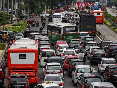 Kendaraan terjebak macet satu arah di Jalan Sudirman - MH Thamrin ketika berlangsungnya aksi peringatan Hari Buruh 2019 di kawasan Bundaran HI, Jakarta, Rabu (1/5/2019). Kemacetan lalulintas ini diakibatkan aksi buruh yang bergerak menuju Istana Negara. (Liputan6.com/Johan Tallo)