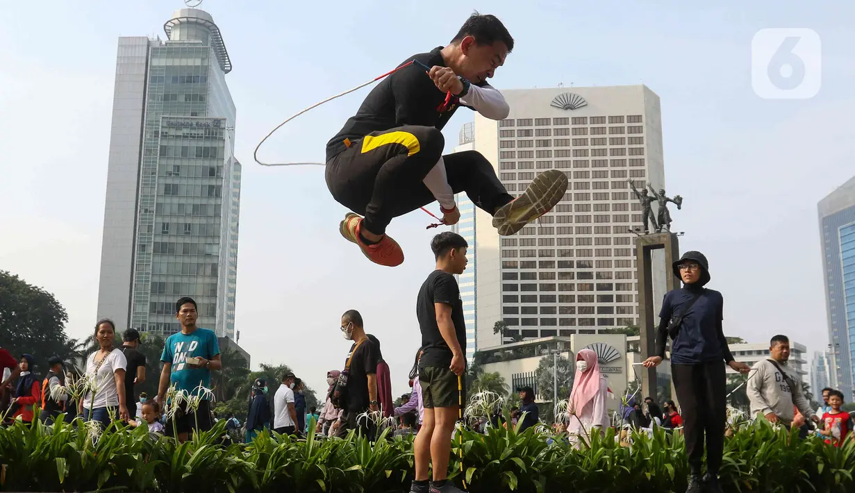 Penggiat lompat tali saat menunjukkan beberapa gerakan di kawasan bundaran Hotel Indonesia, Jakarta, Minggu (12/6/2022). Komunitas Jump Rode Indonesia mensosialisasikan olahraga lompat tali beberapa variasi gerakan ya bisa di pelajari seperti gerakan satu kaki. (Liputan6.com/Herman Zakharia)