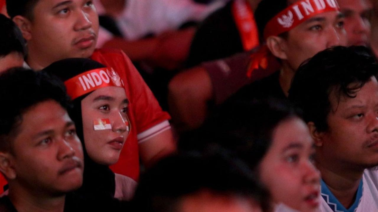 Sejumlah atribut seperti kain ikat kepala bertulisan "Indonesia" hingga stiker bendera Merah Putih yang ditempel di pipi mereka kenakan selama nobar. Foto: Liputan6.com / Herman Zakharia