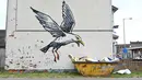 Stensil burung camar yang akan menukik ke sekotak keripik menjadi subjek karya seni grafiti yang menampilkan ciri-ciri seniman jalanan Banksy di dinding Lowestoft di pantai timur Inggris pada 8 Agustus 2021. Karya tersebut belum diklaim oleh Banksy. (JUSTIN TALLIS / AFP)
