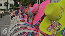 Sepeda onthel berwarna-warni terparkir di halaman Museum Fatahillah, Jakarta, Kamis (17/3). Sepeda berwarna ungu, putih, merah, biru, dll tampak cantik, setelah ditambah topi bundar berenda yang bergantung di tangkai sepeda. (Liputan6.com/Faisal R Syam)