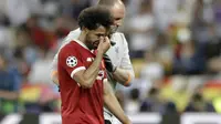 Striker Liverpool, Mohamed Salah, menangis saat ditarik keluar lapangan pada laga final Liga Champions di Stadion NSC Olimpiyskiy, Kiev, Minggu (27/5/2018). Salah mengalami cedera bahu usai dilanggar Ramos. (AP/Matthias Schrader)