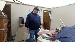 Seorang pria memeriksa barang yang ada dirumahnya usai dilanda tornado di Laramie County, Wyoming, AS (29/5). Usai hantaman tornado tersebut sejauh ini belum ada laporan korban jiwa. (Jacob Byk/The Wyoming Tribune Eagle via AP)