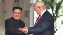 Presiden AS Donald Trump mempersilahkan Pemimpin Korea Utara, Kim Jong-un masuk ke dalam resor Capella, Pulau Sentosa, Singapura, Selasa (12/6). Pertemuan ini merupakan yang pertama kalinya bagi pemimpin AS dan Korut untuk bertatap muka. (SAUL LOEB/AFP)