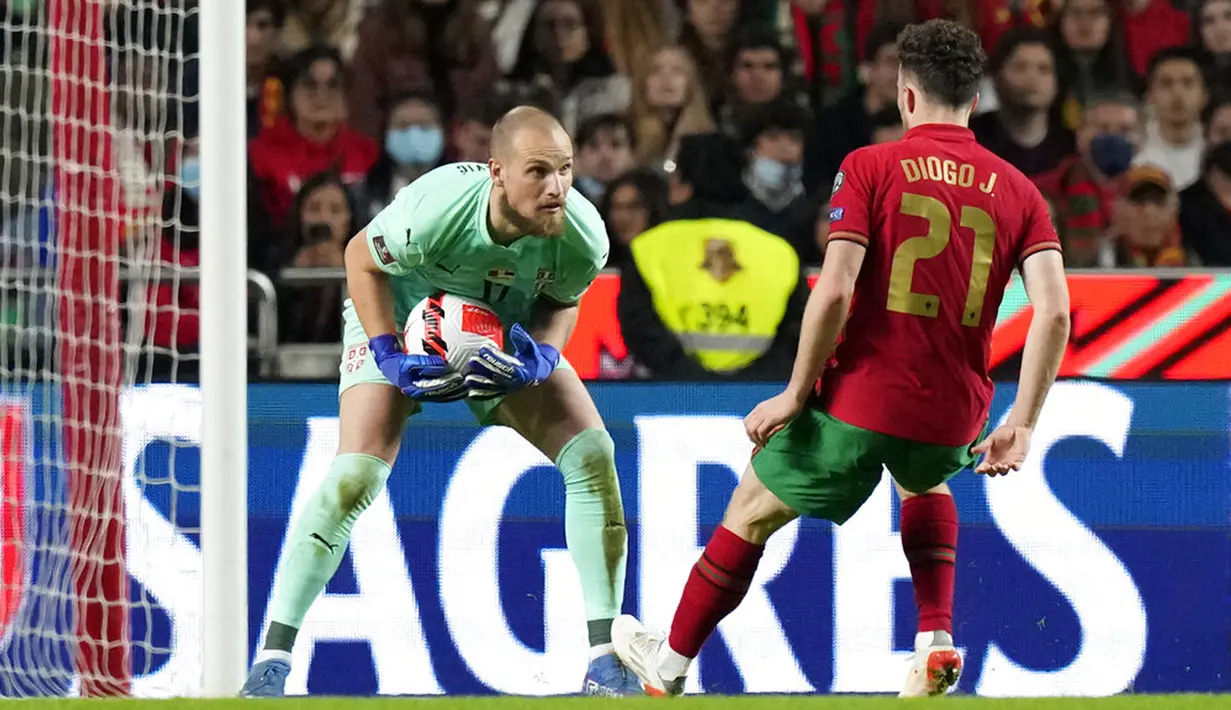 Penjaga gawang Serbia Predrag Rajkovic (kiri) melakukan penyelamatan di depan pemain Portugal Diogo Jota pada pertandingan kualifikasi Grup A Piala Dunia 2022 di Stadion Luz, Lisbon, 14 November 2021. Serbia menang 2-1. (AP Photo/Armando Franca)