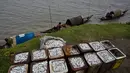 Nelayan  menunggu di kapal mereka untuk menjual hasil tangkapan mereka di tepi sungai Brahmaputra di Jorhat, Assam, India, (3/4). Brahmaputra adalah salah satu sungai terbesar di Asia, yang melewati wilayah China Tibet, India dan Bangladesh sebelum konvergen ke Teluk Benggala. (AP Photo/Anupam Nath)
