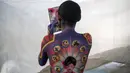 Seorang model memeriksa riasannya selama Daegu International Bodypainting Festival 2017 di Daegu, Korea Selatan, (26/8). Para model hanya menggunakan celana dalam dan plester di dadanya untuk dijadikan kanvas hidup oleh seniman seni lukis (Ed JONES / AFP)