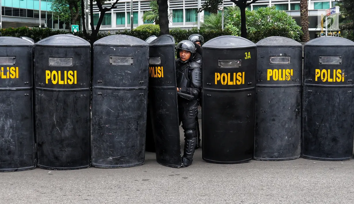 Sejumlah anggota polisi menggunakan tameng untuk menutup jalan pada peringatan Hari Buruh 2019 di kawasan Bundaran HI, Jakarta, Rabu (1/5/2019). Massa buruh yang hendak ke Istana Negara harus berhadapan dengan polisi karena tidak bisa melewati kawasan Bundaran HI. (Liputan6.com/Johan Tallo)