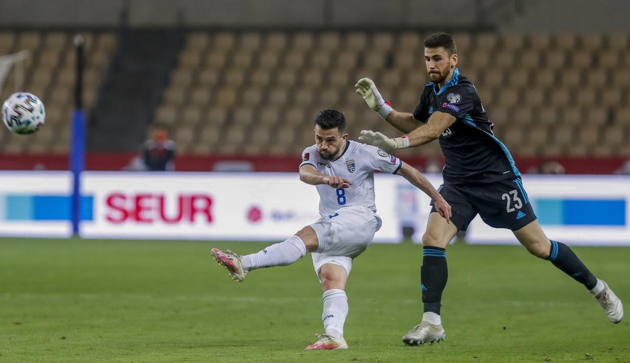 Gelandang Kosovo, Besar Halimi (kiri) melepaskan tendangan ke gawang Spanyol yang kosong ditinggalkan kiper Unai Simon dalam laga lanjutan Kualifikasi Piala Dunia 2022 Zona Eropa Grup B di La Cartuja Stadium, Sevilla, Rabu (31/3/2021). Kosovo kalah 1-3 dari Spanyol. (AP/Miguel Angel Morenatti)