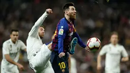 Striker Barcelona, Lionel Messi berusaha membawa bola dari kawalan bek Real Madrid, Sergio Ramos selama pertandingan lanjutan La Liga Spanyol di Santiago Bernabeu, Madrid (2/3). Barcelona menang tipis atas Real Madrid 1-0. (AP Photo/Manu Fernandez)