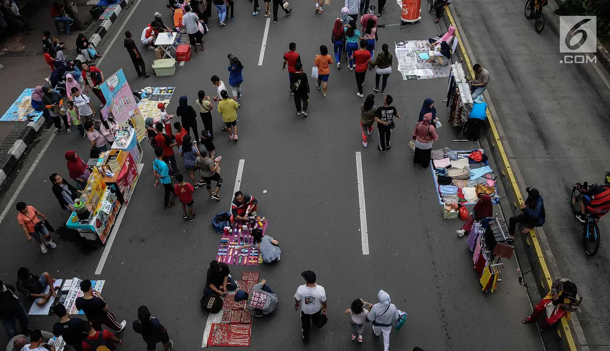 Pedagang Kaki Lima (PKL) berjualan selama kegiatan Car Free Day (CFD) di sepanjang Jalan Sudirman, Jakarta, Minggu (9/12). Kurangnya pengawasan menyebabkan banyak PKL yang berjualan tidak pada tempatnya dan memenuhi area CFD. (Liputan6.com/Faizal Fanani)