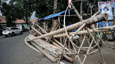 Kendaraan melintas di depan tumpukkan pohon pinang yang dijual di Jalan Manggarai Utara, Jakarta, Selasa (11/8/2020). Penjualan pohon pinang tahun ini menurun drastis dibandingkan tahun sebelumnya akibat pandemi Covid-19 yang menyebabkan larangan sejumlah perlombaan. (merdeka.com/Iqbal Nugroho)