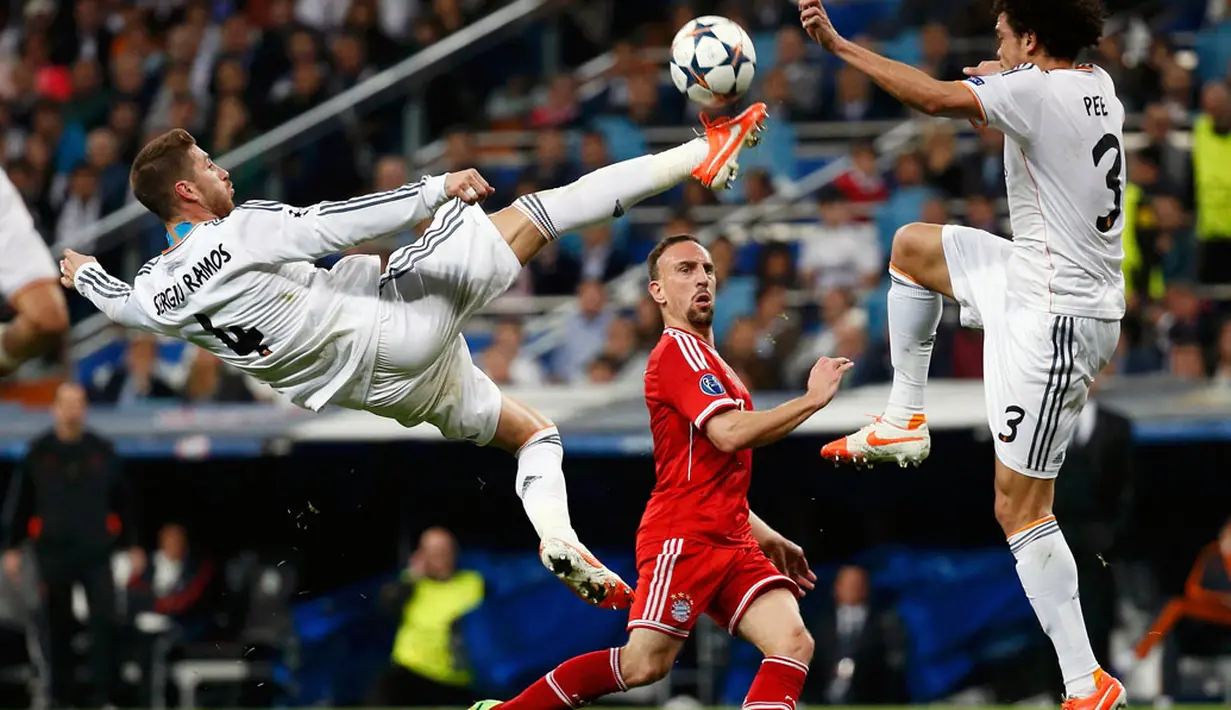 Pemain bertahan Real Madrid, Sergio Ramos (kiri) melompat merebut bola yang mengarah ke Frank Ribery (Bayern Munich) dalam laga pertama semifinal Liga Champions di Stadion Santiago Bernabeu, Madrid, Spanyol (24/4/2014). (REUTERS/Paul Hanna)