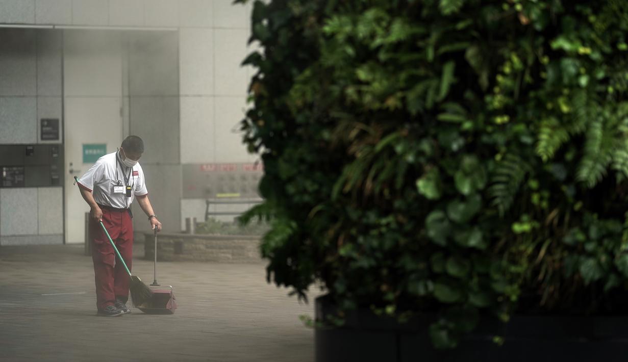 Seorang pegawai gedung yang memakai masker untuk membantu mencegah penyebaran virus corona membersihkan di dekat area kabut di Tokyo, Kamis (10/9/2020). Ibu kota Jepang itu mengonfirmasi lebih dari 270 kasus virus corona pada Kamis. (AP Photo / Eugene Hoshiko)