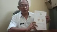 Kepala Kesbangpol Garut Wahyudijaya menunjukan perubahan posisi dan komposisi lambang negara Garuda Pancasila yang dilakukan Ketua paguyuban Kandang Wesi Tunggul Rahayu, Cisewu, Garut, Jawa Barat. (Liputan6.com/Jayadi Supriadin)