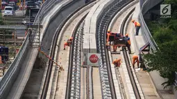 Pekerja menyelesaikan pembangunan LRT (Light Right Transit) Jabodebek di kawasan Kampung Makasar, Jakarta, Sabtu (26/10/2019). LRT akan diuji coba pada awal November 2019. (Liputan6.com/JohanTallo)