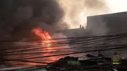 Petugas pemadam kebakaran berusaha memadamkan api yang melanda daerah kumuh di Manila, Filipina (23/5). Menurut laporan media setempat, kebakaran tersebut menghancurkan 200 rumah yang mempengaruhi 300 keluarga. (AFP Photo/Noel Celis)