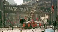 Petugas pemadam kebakaran berjalan di tengah puing-puing di lokasi ledakan bom di pusat Manchester, 180 mil utara London, 15 Juni 1996. (AP)