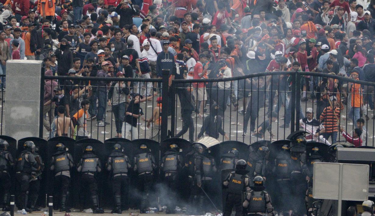 Petugas Kepolisian berusaha menghalau suporter Persija Jakarta yang memaksa masuk komplek SUGBK untuk menyaksikan laga melawan Mitra Kukar pada laga Liga 1, Jakarta, Minggu (09/12). Persija menang 2-1 atas Mitra Kukar. (Bola.com/M Iqbal Ichsan)