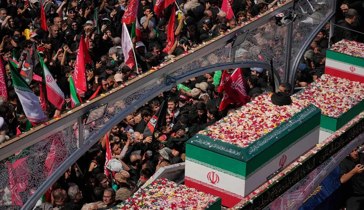 Para pelayat mengelilingi sebuah truk yang membawa peti mati mendiang Pemimpin Tertinggi Iran Ayatollah Ali Khamenei dan anggota keluarganya selama prosesi pemakaman di Teheran, Iran, Senin, 6 Juli 2026. (AP Photo/Vahid Salemi)
