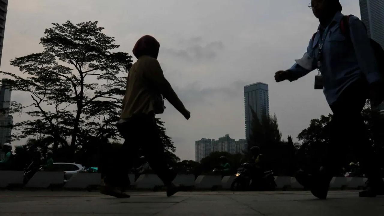 Aktivitas pekerja saat melintasi trotoar di kawasan Jalan Jenderal Sudirman, Jakarta, Selasa (21/11/2023)  Pemrov DKI Jakarta resmi menetapkan kenaikan Upah Minimum Provinsi (UMP) DKI Jakarta.<br>