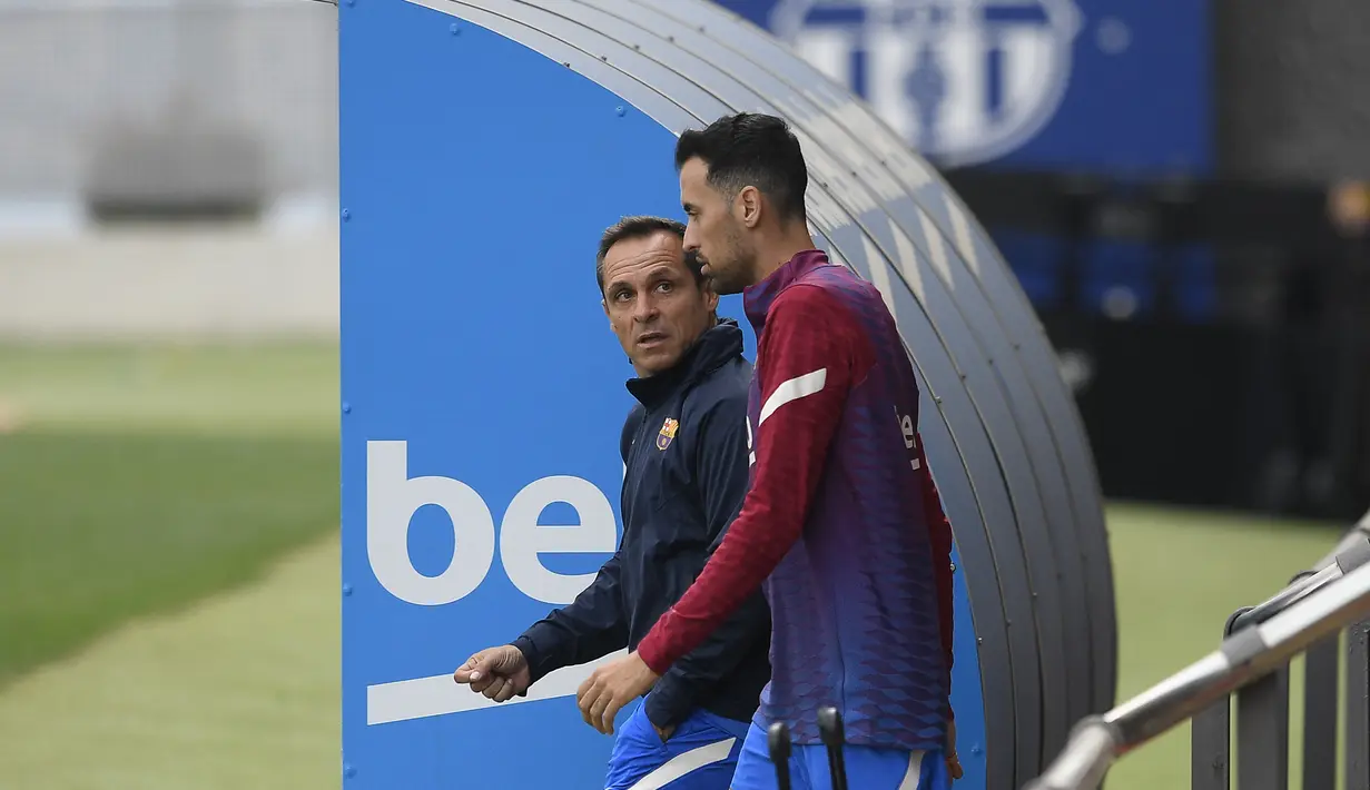 Pelatih interim Barcelona, Sergi Barjuan (kiri) dan Sergio Busquets tiba untuk sesi latihan menjelang lanjutan Liga Spanyol melawan Deportivo Alaves di Barcelona, Kamis (29/10/2021). Latihan pertama Barcelona dipimpin Sergi Barjuan sambil nunggu kedatangan Xavi Hernandez. (Josep LAGO/AFP)