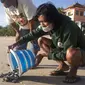 Seorang sukarelawan melepaskan bayi penyu ke laut di Bali, Indonesia, Selasa (6/7/2021). Puluhan penyu Lekang yang baru menetas dilepasliarkan dalam kampanye penyelamatan penyu yang terancam punah. (AP Photo/Firdia Lisnawati)