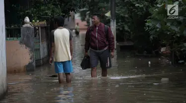 Warga beraktivitas saat banjir merendam kawasan Cipinang Melayu, Jakarta Timur, Senin (5/2). Akibat intensitas hujan yang cukup tinggi, permukiman di wilayah Cipinang Melayu tergenang air setinggi 30-40 cm. (Liputan6.com/Arya Manggala)