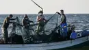 Nelayan Palestina mengumpulkan hasil tangkapan dari jaring saat menangkap ikan di Laut Mediterania, Rafah, Jalur Gaza, Rabu (2/9/2020). (SAID KHATIB/AFP)