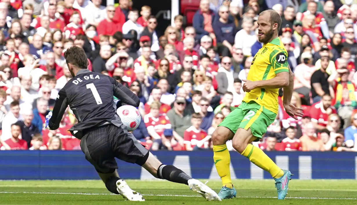 Kiper Manchester United David de Gea (kiri) menyelamatkan gawangnya dari tendangan pemain Norwich City Teemu Pukki pada pertandingan sepak bola Liga Inggris di Stadion Old Trafford, Manchester, Inggris 16 April 2022. Manchester United menang 3-2. (AP Photo/Jon Super)