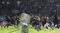 Kericuhan tak terelakkan di stadion yang menjadi markas Arema FC itu. Aremania turun ke lapangan setelah tim kesayangan mereka kalah dari rival bebuyutannya. (AP/Yudha Prabowo)