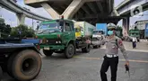 Polisi Lalu Lintas dan Dinas Perhubungan Daerah Khusus Jakarta melakukan pengaturan keluar masuk kendaraan truk kontainer di area Perempatan Pos IX Pelabuhan Tanjung Priok, Jakarta Utara, Jumat (18/4/2025). (Liputan6.com/Angga Yuniar)
