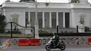 Pengendara motor melintas di depan Istana Negara, Jakarta, Selasa (24/11). Aktivitas serta lalu lintas di sekitar Istana masih terlihat sepi dan kondusif meskipun kawasan tersebut menjadi salah satu tempat aksi mogok buruh (Liputan6.com/Immanuel Antonius)