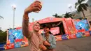Pengunjung melakukan swafoto di depan panggung Fan Zone Piala Dunia FIBA 2023 yang terletak di Senayan Park, Jakarta, Rabu (23/08/2023). (Bola.com/Bagaskara Lazuardi)